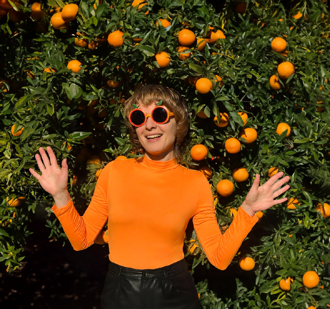 Lisa Erbak standing next to an orange tree